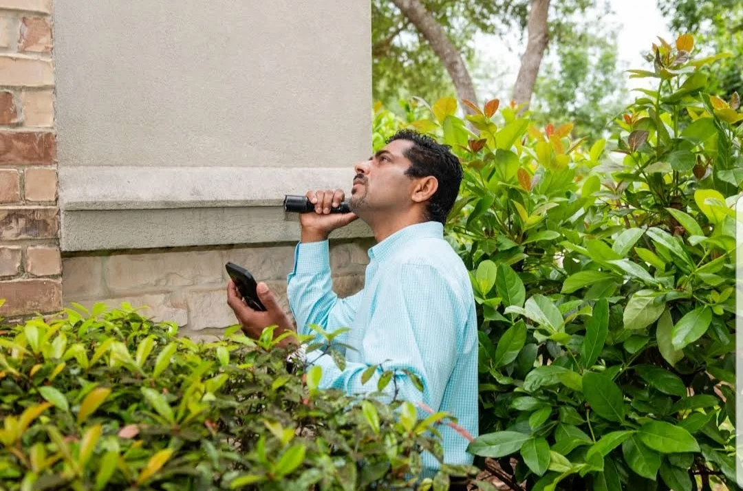 Alex Mathew checking a home exterior during field work